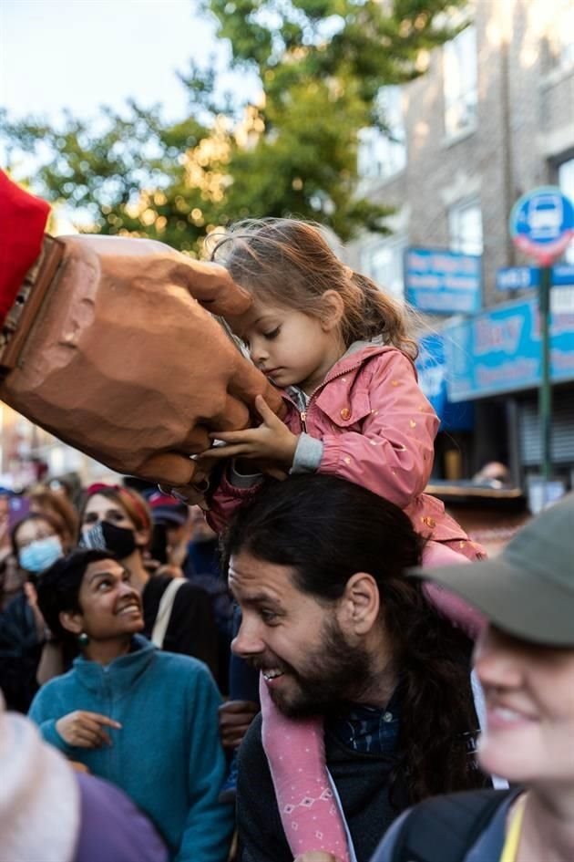 Amal ha conmovido con su mensaje de esperanza a personas adultas y a la niñez de los sitios que visita. En esta fotografía da la mano a una niña en NY.