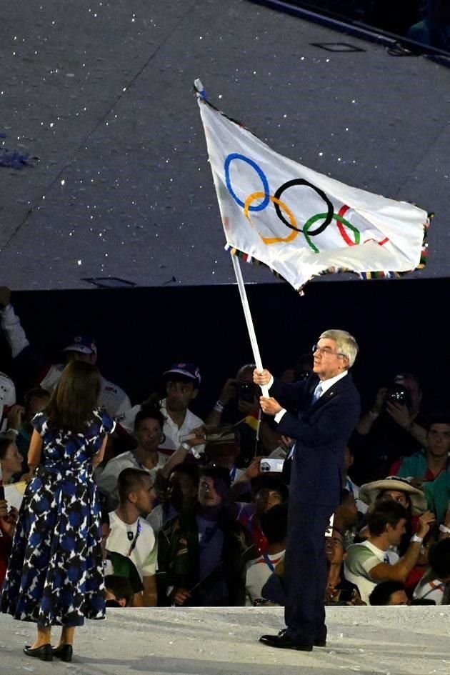 Thomas Bach, presidente del COI, ondea la bandera olímpica junto a la alcaldesa de París, Anne Hidalgo.