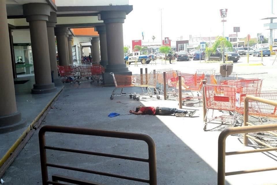 Uno de los abatidos quedó a la entrada de la tienda.