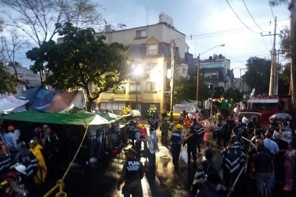 Sobre la calle Brujas, rescatistas instalaron algunas lonas para resguardarse de la lluvia.