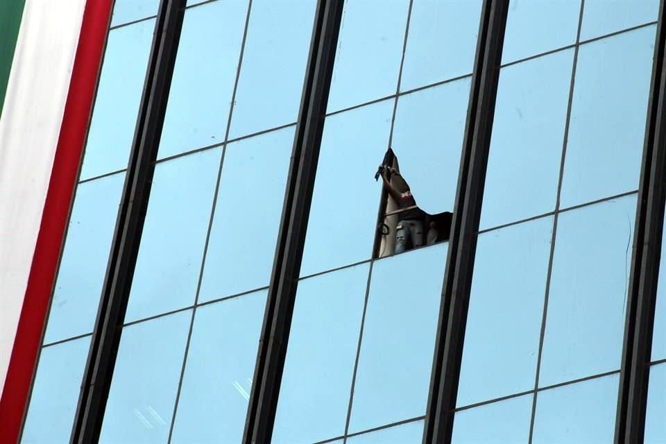 Empleados de una empresa vidriera acudieron ayer a retirar los cristales dañados en la fachada de las oficinas centrales de la PGR en Paseo de la Reforma 211-213.