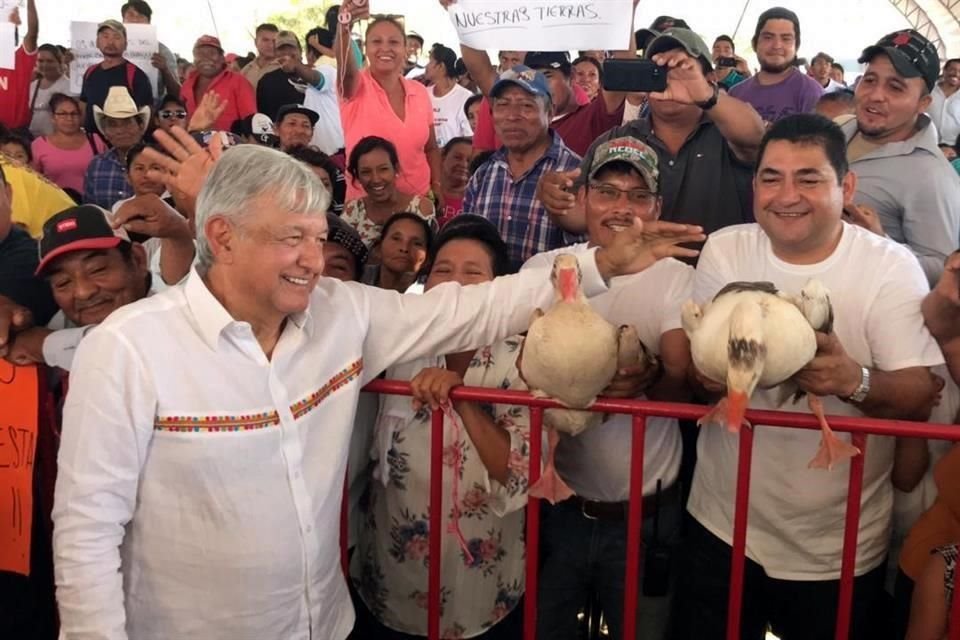 AMLO acarició a los dos gansos y fue fotografiado junto a ellos.