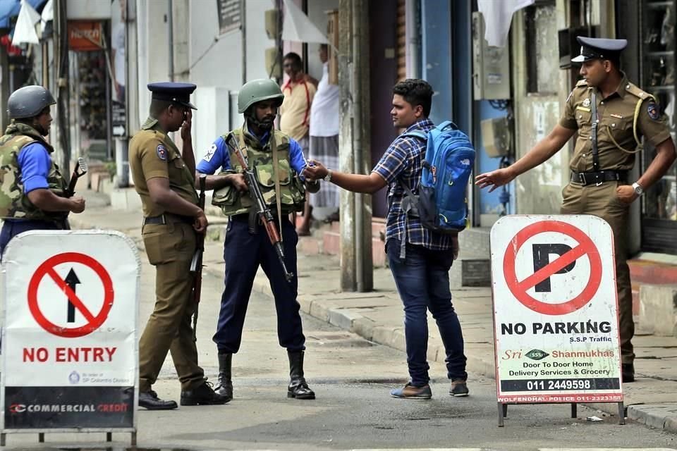 Policías de Sri Lanka verifican la identificación de una persona que lleva una mochila en Colombo, Sri Lanka