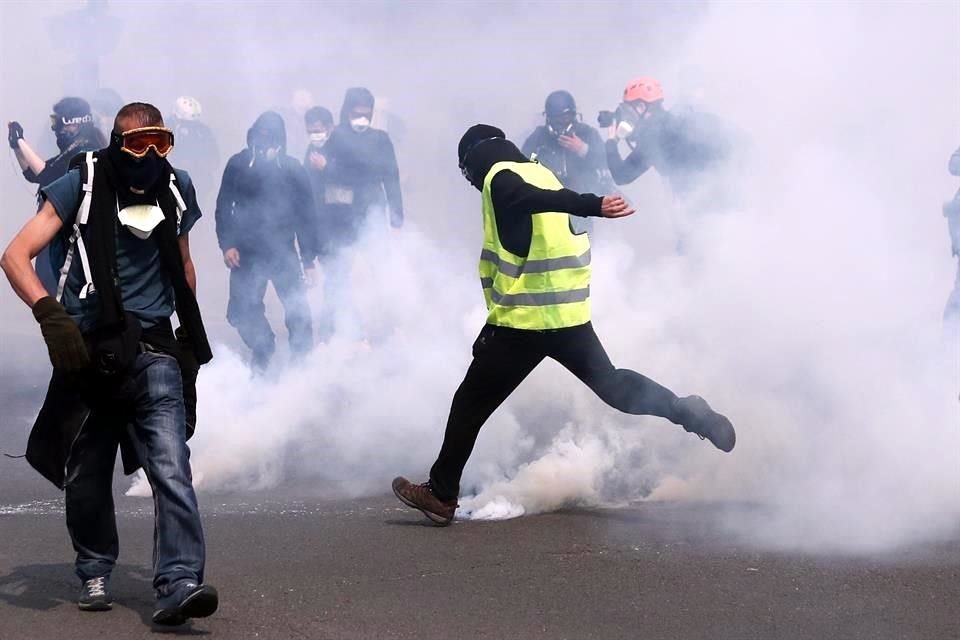 Un manifestante arroja un proyectil a la policía antidisturbios durante una manifestación de los sindicatos y de los 'chalecos amarillos'.