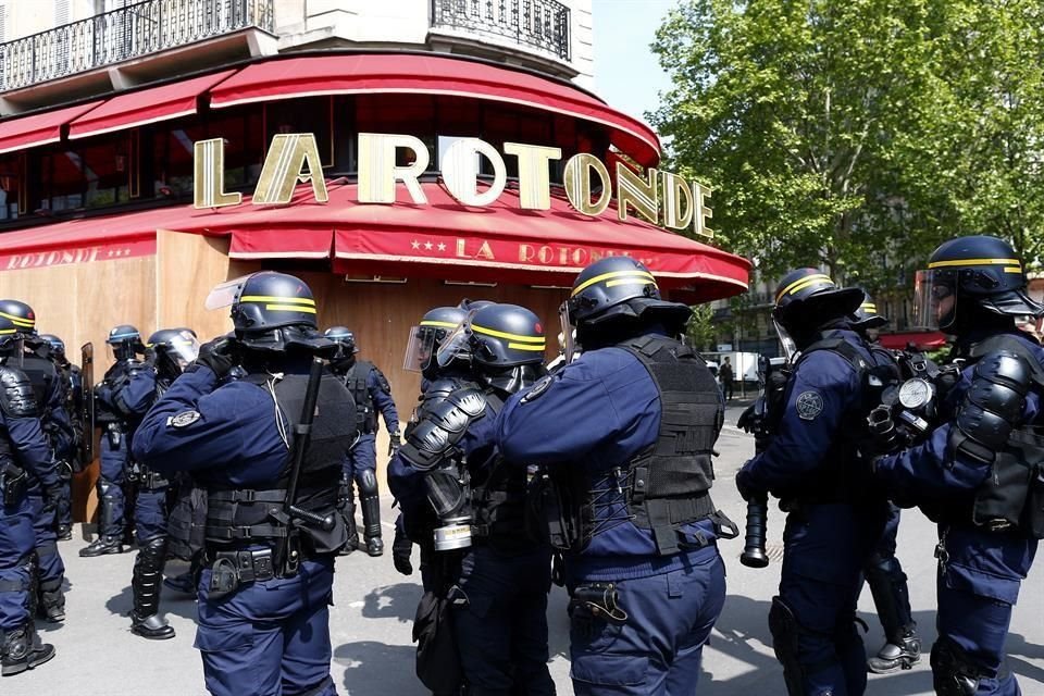 Policías antidisturbios galos protegen el restaurante La Rotonde durante una manifestación de los sindicatos galos y de los 'chalecos amarillos'.