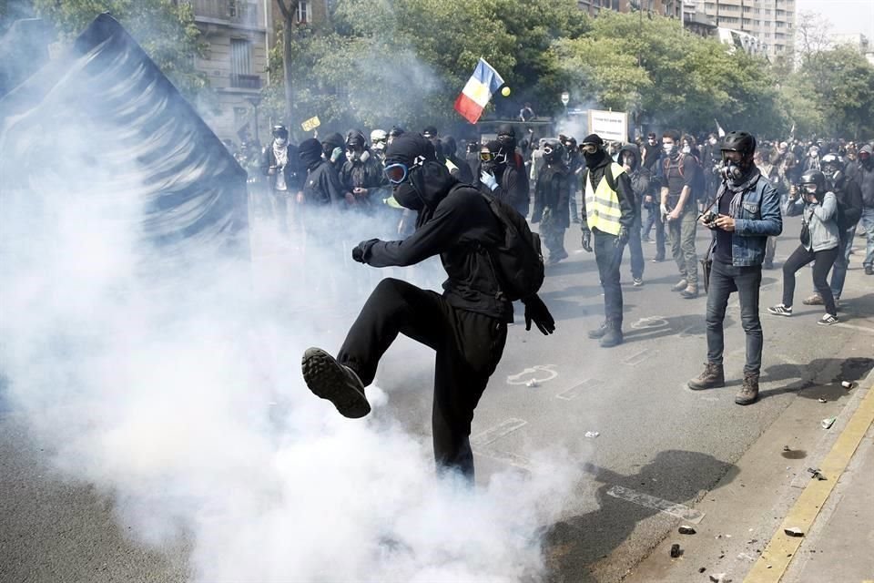 Un activista arroja un proyectil a la policía antidisturbios durante una manifestación de los sindicatos galos.