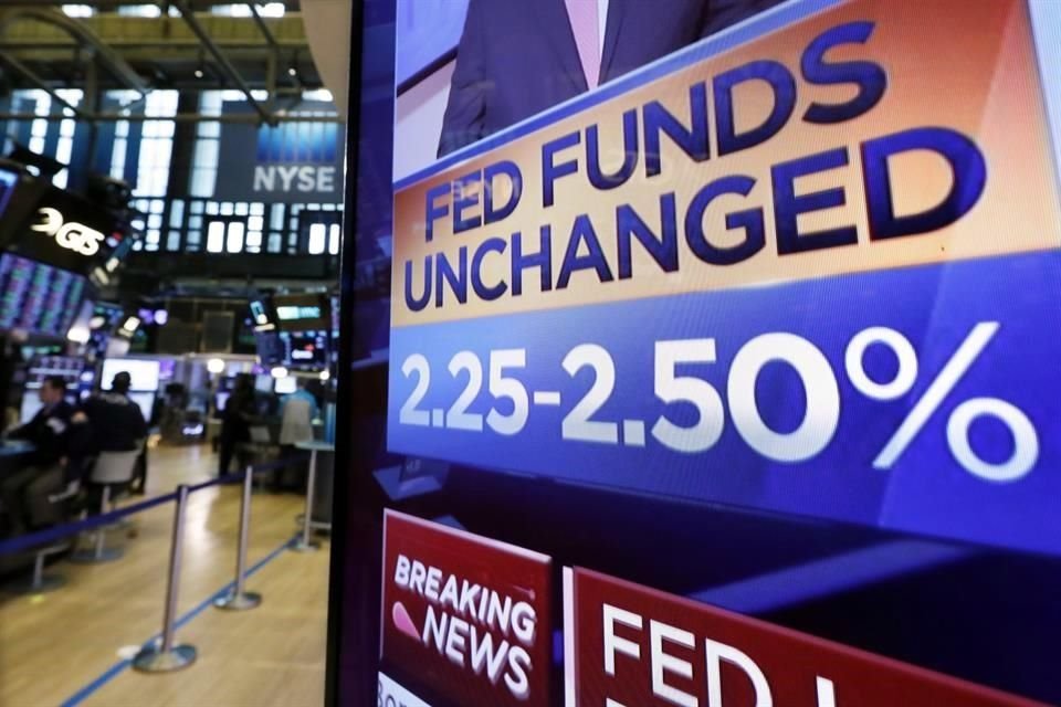 Tablero muestra decisión de la Fed en el piso de remates del NYSE.