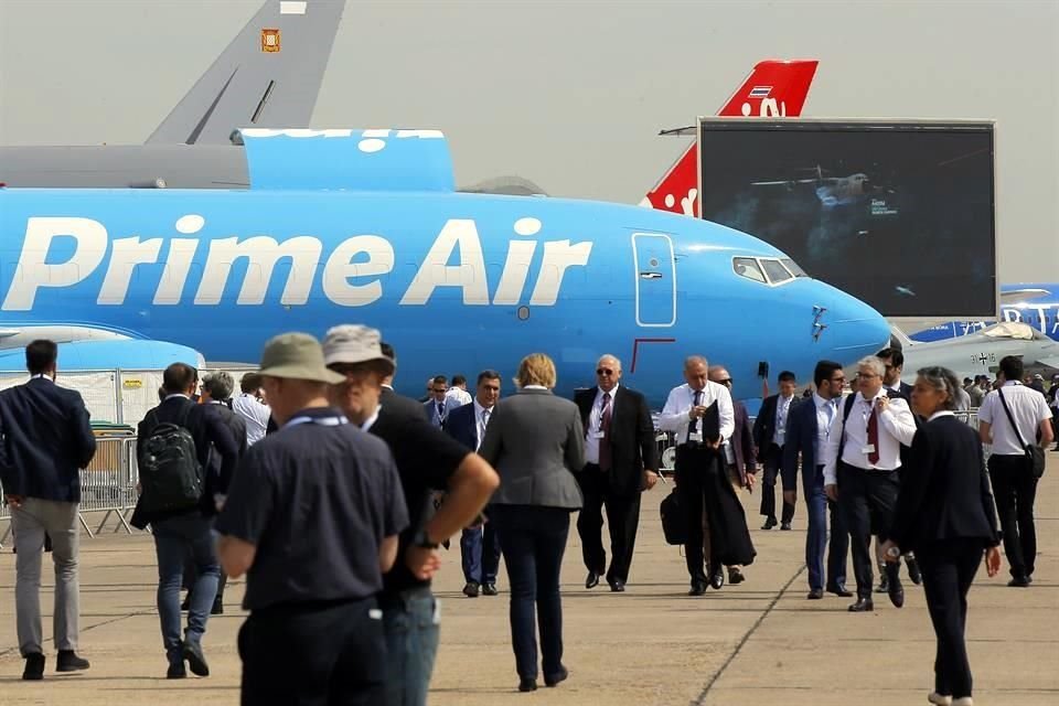 Los visitantes al Salón Aeronáutico pasan frente a un avión de carga 'Prime Air', modelo Boeing 737-800.