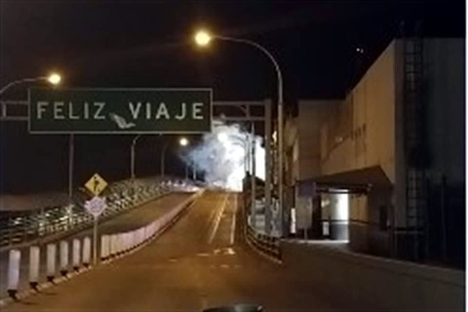 Al fondo, en la mitad del puente, se observa gas lanzado por autoridades estadounidenses durante la madrugada.