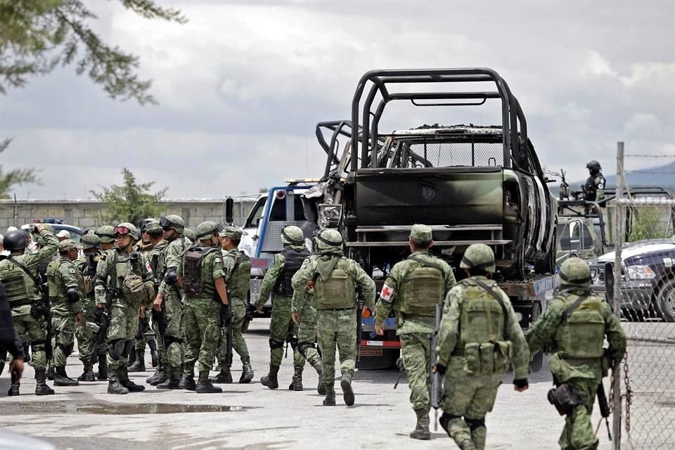 Elementos de la Guardia Nacional, Policía estatal y ministerial resguardan la zona donde fueron incendiadas dos unidades de Petróleos Mexicanos.