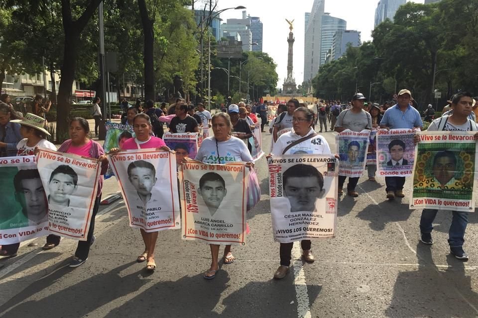 Familiares caminando sobre los carriles centrales de Paseo de la Reforma, mientras estudiantes de la Normal Rural Raúl Isidro Burgos corean consignas.