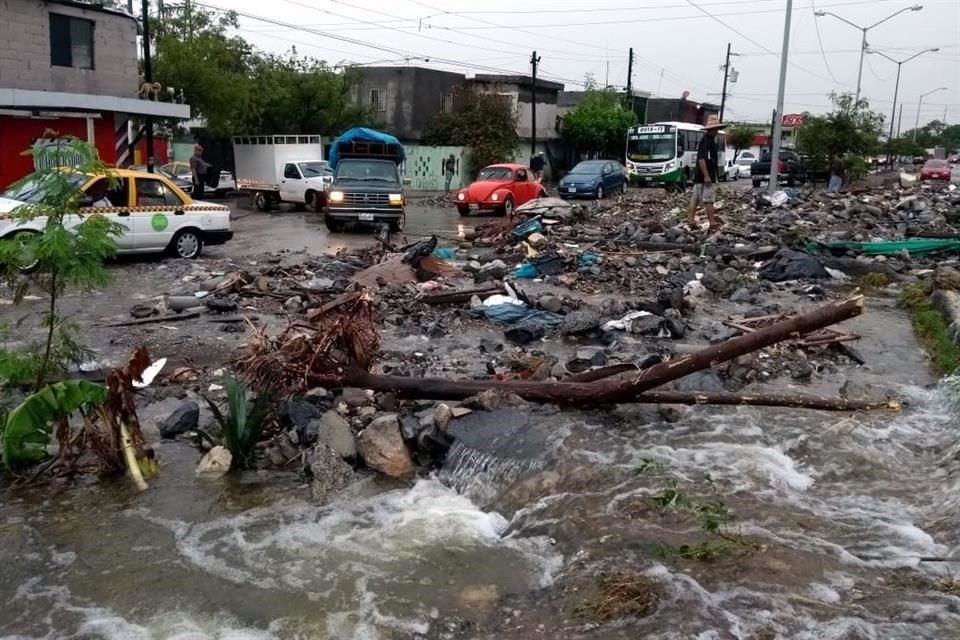 Vecinos salieron a la Avenida Camino Real, la cual lucía un panorama desolador con el pavimento levantado, con corrientes de agua provenientes del Cerro del Topo Chico y un alud de rocas y lodo.