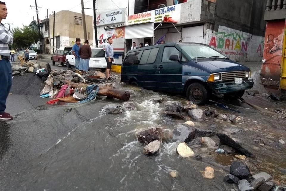 Vecinos salieron a la Avenida Camino Real, la cual lucía un panorama desolador con el pavimento levantado, con corrientes de agua provenientes del Cerro del Topo Chico y un alud de rocas y lodo.