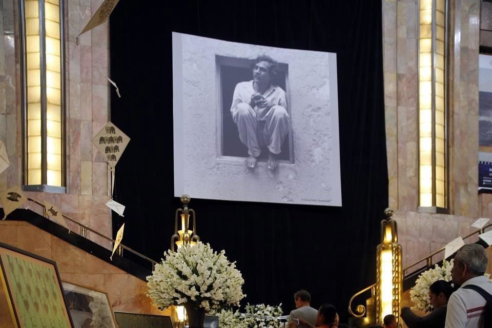 Arriba, pegada a lo alto de la pared, la fotografía de Toledo en cuclillas sobre una ventana, tomada por Graciela Iturbide.