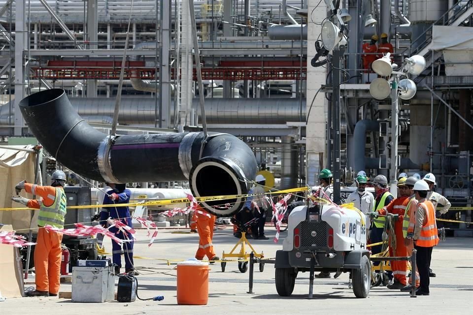 Trabajadores arreglan una tubería en el sitio dañado de la instalación petrolera Saudi Aramco en Khurais, Arabia Saudita.