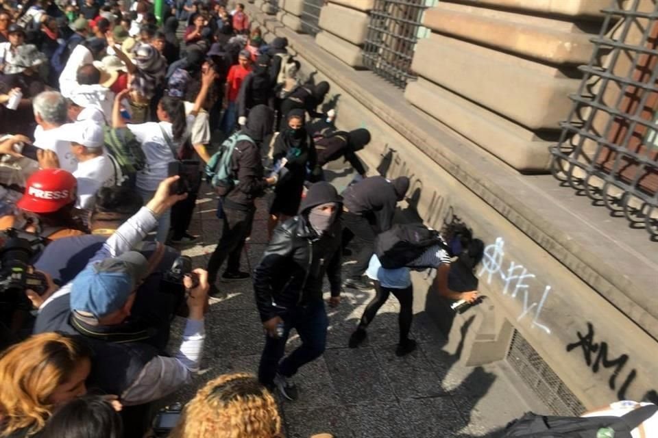 Personas encapuchadas realizan pintas en los edificios.