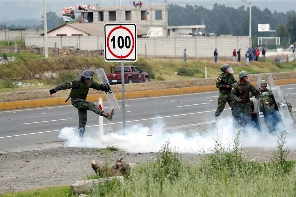 Un soldado patea una lata de gas lacrimógeno hacia los manifestantes.