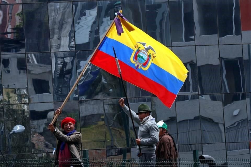 Un manifestante agita una bandera de Ecuador frente a la Asamblea Nacional.