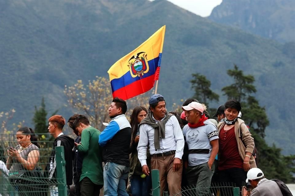 Manifestantes sostienen banderas afuera de la Asamblea Nacional de Ecuador.