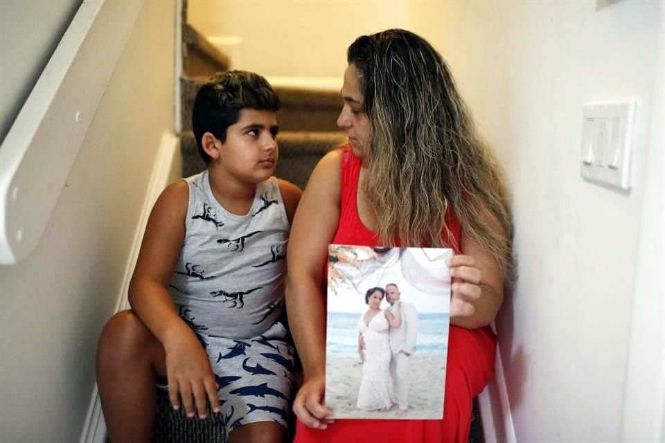 Barbara Rodriguez y su hijo, Nolan Aragon, de 9 años. Rodríguez sostiene una fotografía de la boda de ella y su esposo, Pablo Sánchez.