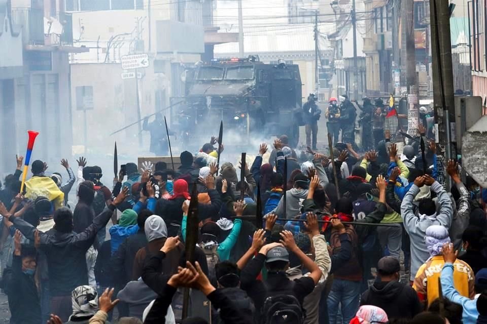 Manifestantes alzan las manos en señal de paz.