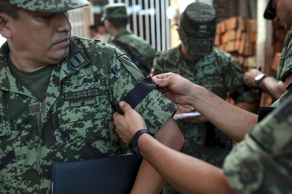 Durante el sepelio, agentes se colocaron un listón negro en el antebrazo.