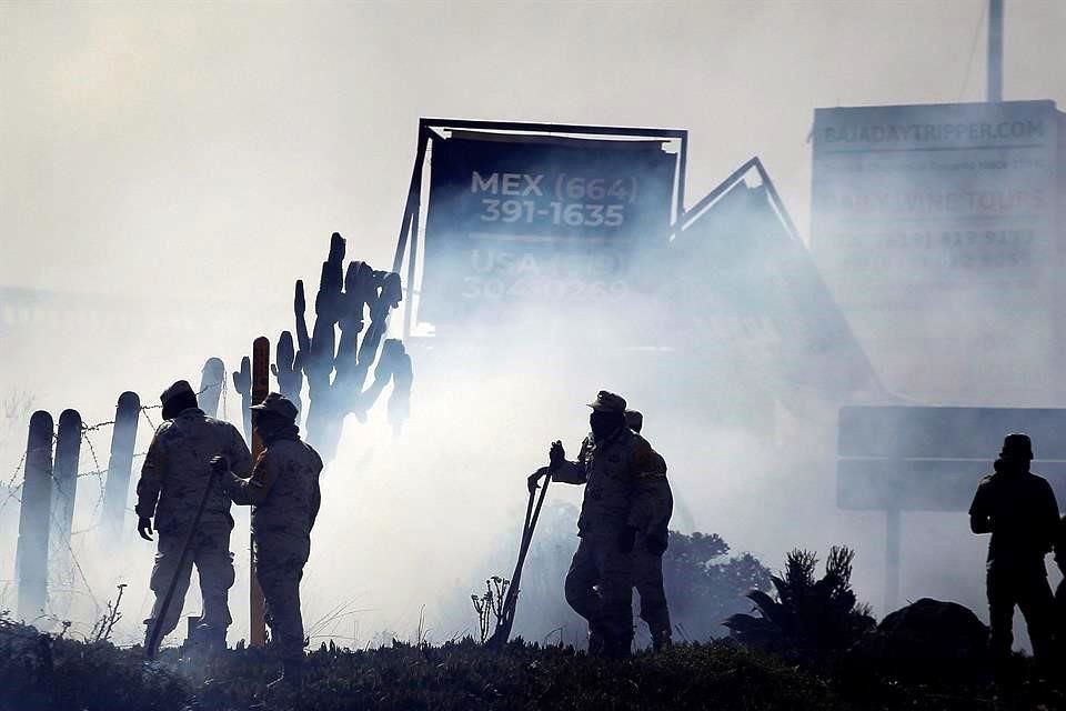 Miembros de la Guardia Nacional intentan sofocar incendio en Tijuana.