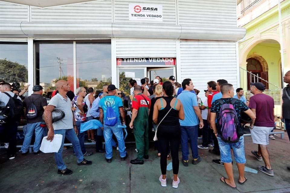 Varias personas hacen colas para la compra de los productos que salen a la venta en dólares en tiendas cubanas, este lunes en La Habana.