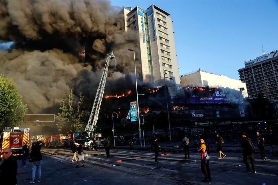 Un incendio se registra en una plaza comercial ubicada en el centro de la capital chilena en medio de las protestas contra el Gobierno de Piñera.