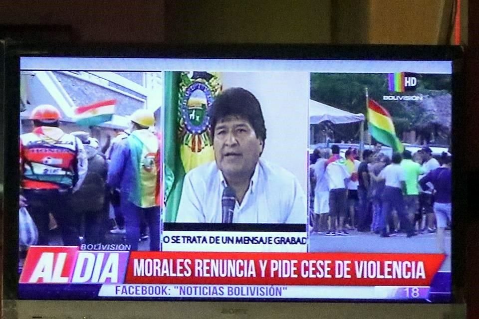 Ciudadanos bolivianos observan en una pantalla la renuncia del presidente de Bolivia, Evo Morales.