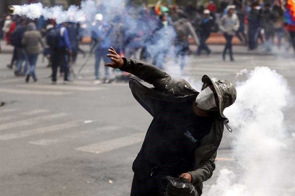 Un manifestante devuelve una lata con gas durante una protesta en Bolivia.