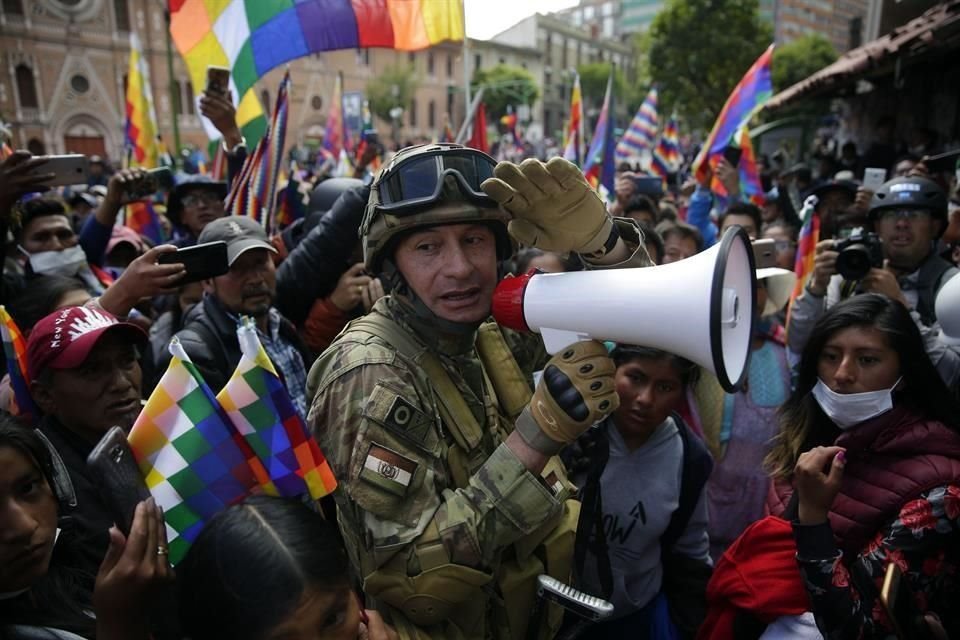 Indígenas y simpatizantes de Evo Morales protestan este viernes bajo la vigilancia de policías.