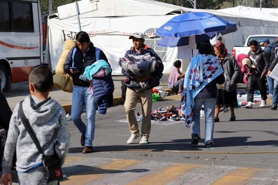 Con banderas rojas en mano, los integrantes de Antorcha Campesina se dirigen a los camiones para abordarlos rumbo a sus entidades de origen.