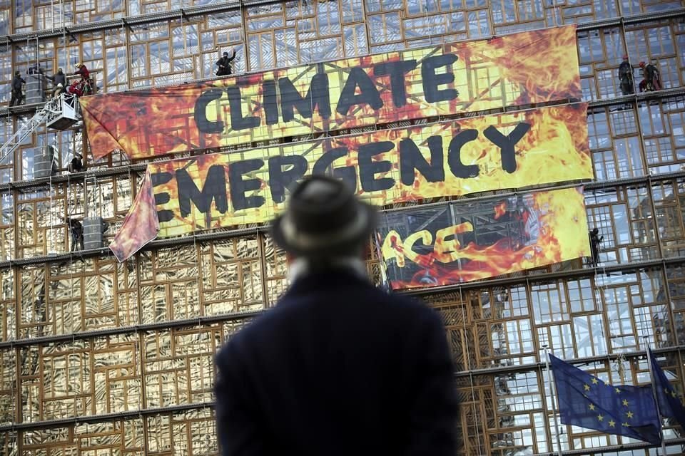 Manifestantes de Greenpeace cuelgan una manta en Bruselas.