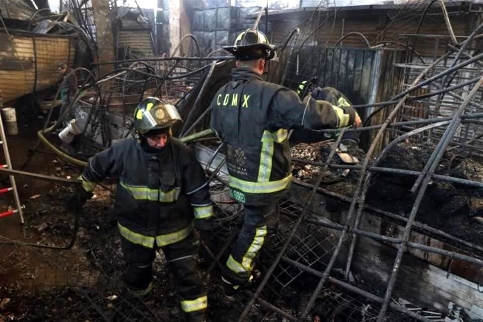 Los comerciantes comenzaron a hacer su propia remoción de escombros, mientras bomberos aún apagaban fumarolas de algunos puestos.