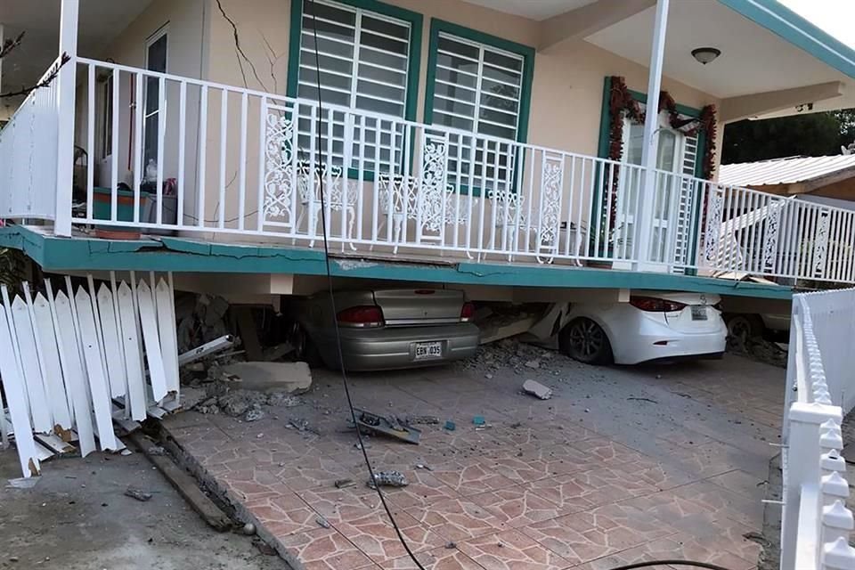 Una de las casas desplomadas aplastó vehículos.