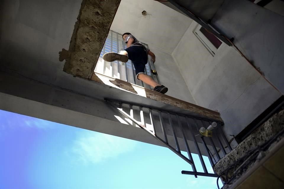 Un joven camina dentro de su casa luego de que se desplomara una parte durante el sismo.