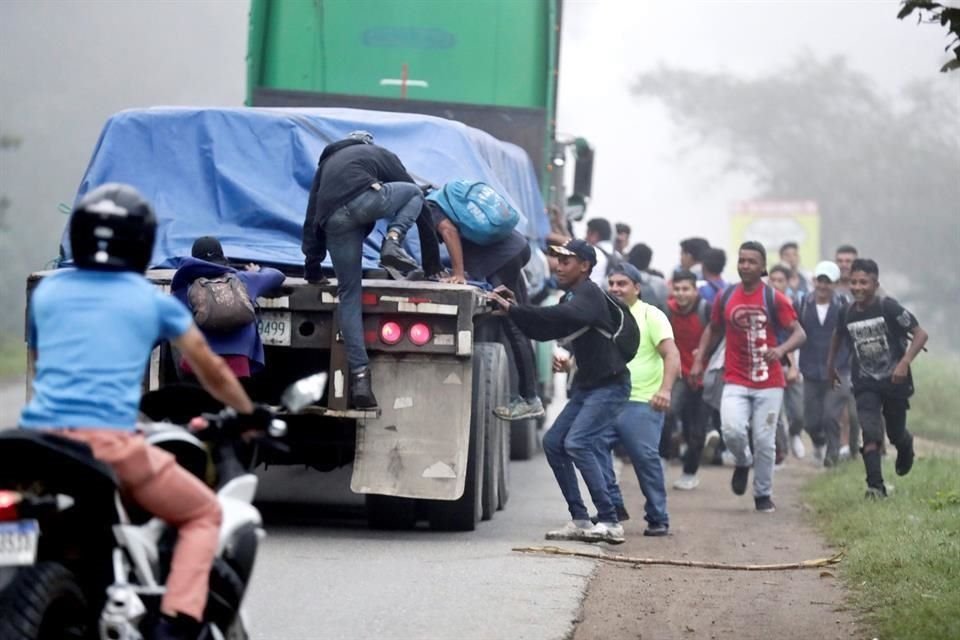 Migrantes hondureños montan en un camión, tras partir la Gran Central Metropolitana de la ciudad de San Pedro Sula.