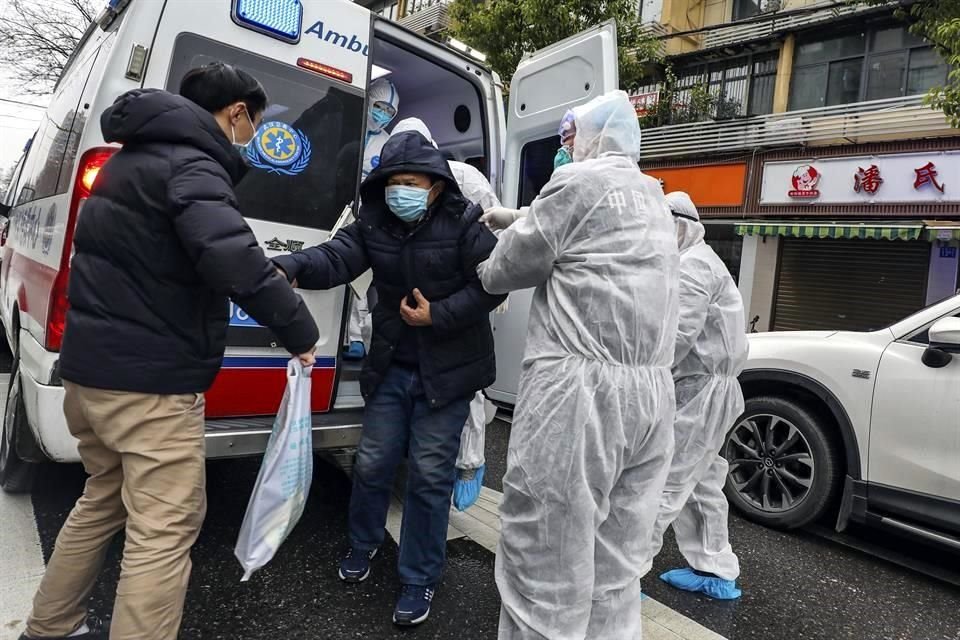 Médicos ayudan a un paciente a bajar de una ambulancia en la ciudad de Wuhan.