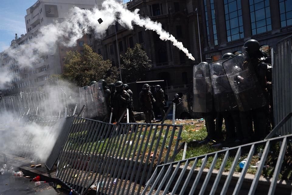 Fuerzas Especiales de Carabineros intervienen este domingo durante una multitudinaria marcha de mujeres por el Día Internacional de la Mujer, en Santiago.