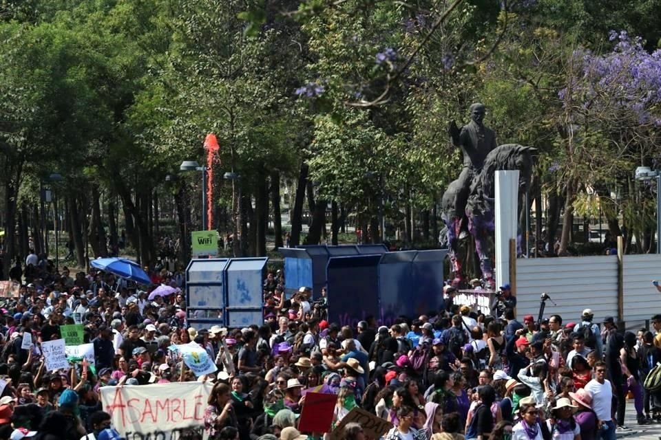 Mujeres encapuchadas lograron quitar una valla metálica y pintó la estatua de Madero.