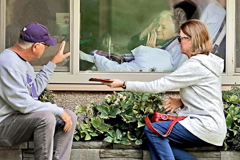 Una mujer infectada es visitada por sus familiares en un hospital de EU.