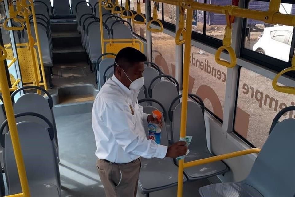 Trabajadores realizan la limpieza de los tubos, asientos y área del conductor al terminar el recorrido del camión.