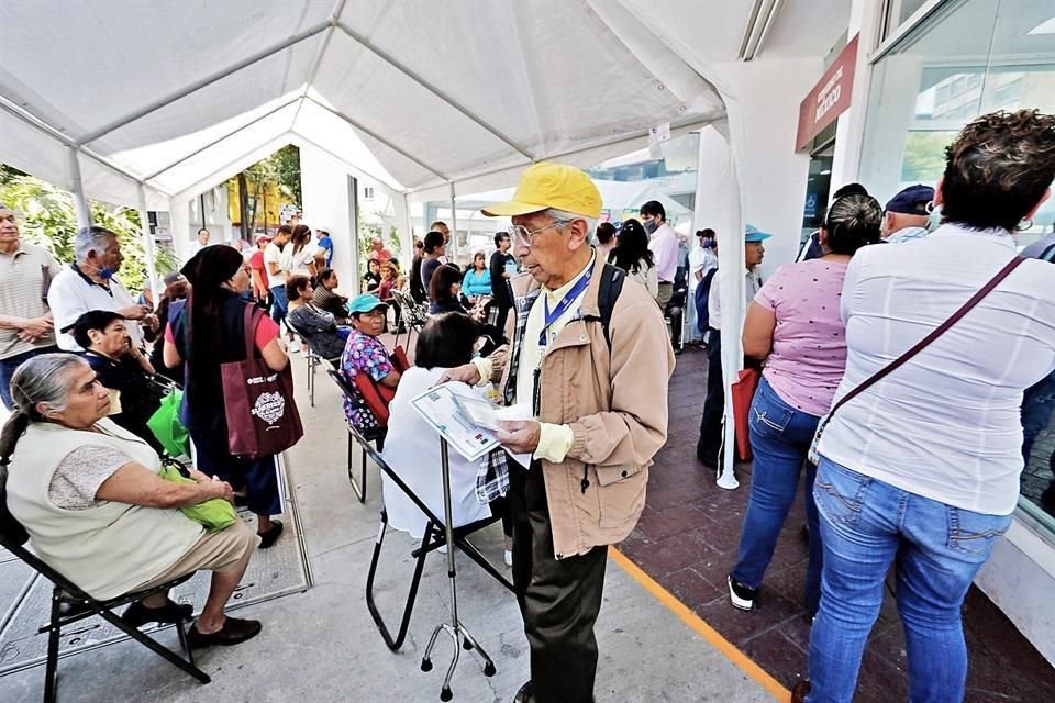 Adultos mayores esperan su turno dentro de una carpa blanca, habilitada por la Secretaría, donde hay decenas de personas.