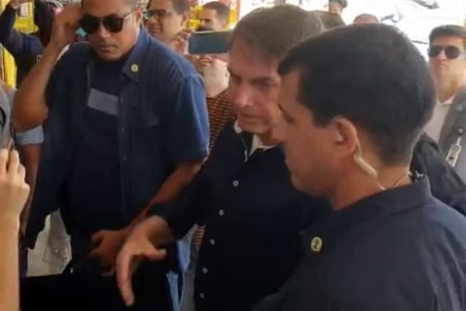 Bolsonaro (izq, en medio), platicó con vecinos de comunidades en Brasilia, pese a que otros miembros de su Gobierno han pedido que la gente no salga de casa a menos que sea necesario.