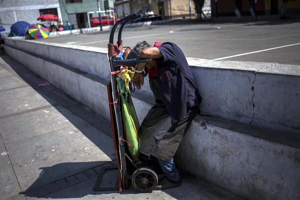 Un trabajador descansa afuera de un mercado en Lima, Perú.