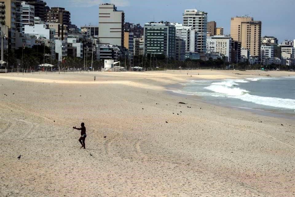 Un hombre camina en una playa vacía en de Leblon este martes, en Río de Janeiro (Brasil).