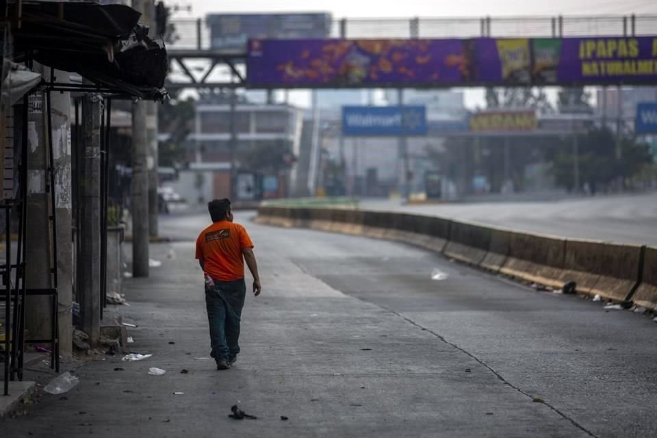 Un hombre camina en la avenida Roosevelt en la Ciudad de Guatemala.