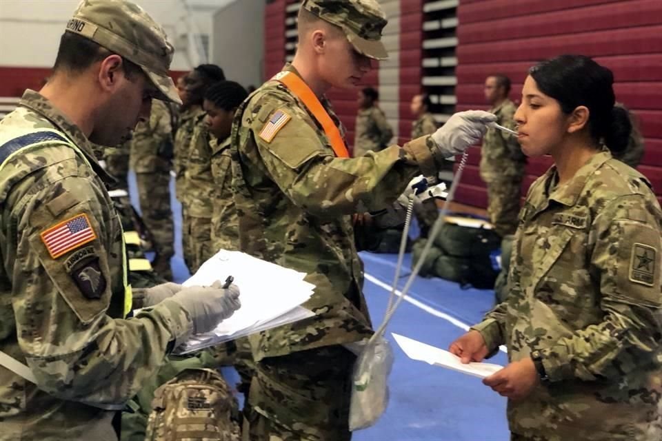 Recién graduados del entrenamiento básico de combate del Ejército pasan por controles de temperatura.