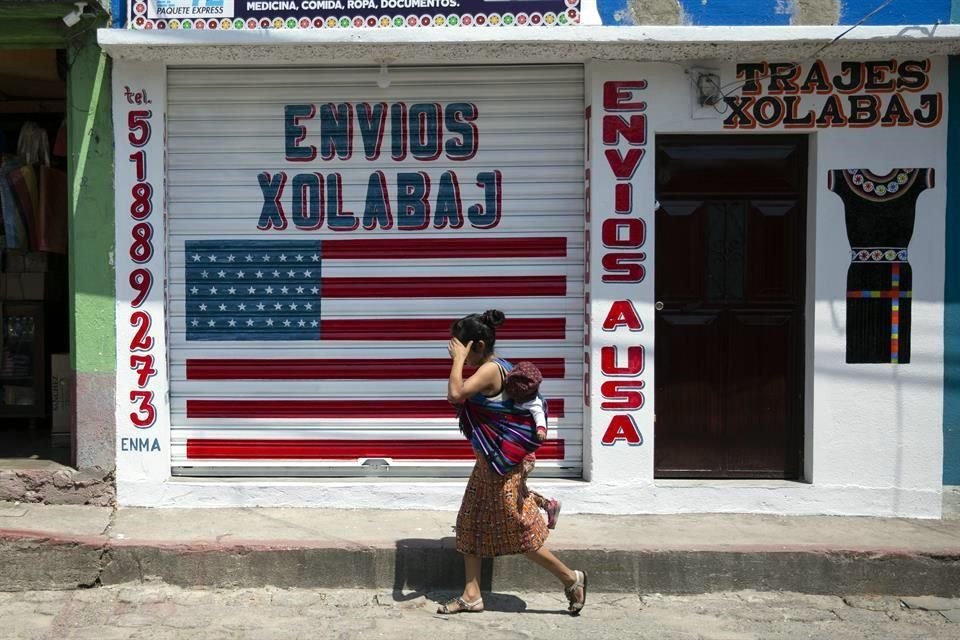 Una mujer en Guatemala camina frente a una oficina cerrada de envíos a Estados Unidos.